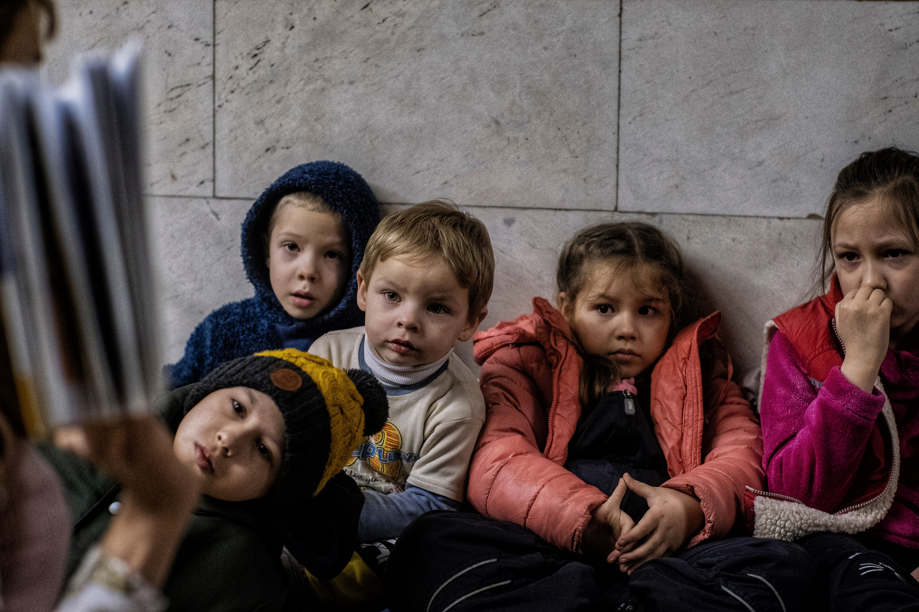 Children, are read stories by a teacher to continue their education, who were living underground in the metro stations in Kyiv, to protect against Russian rocket attacks.