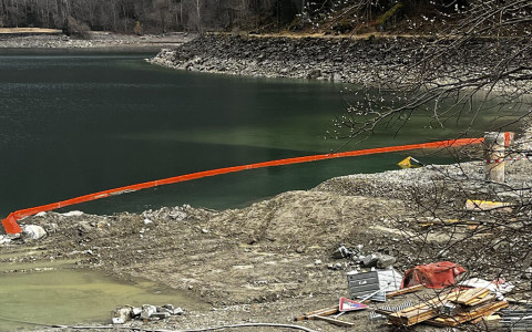 Escavatrice e compressore nel lago a Miralago